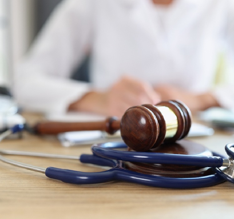 Photo of the judge's gavel on a table with a stethoscope